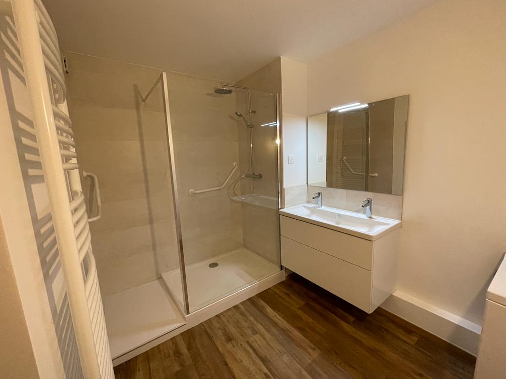 Salle de bain beige avec douche italienne